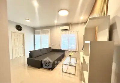 Modern living room with sleek gray sofa and glass coffee table