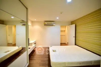 Spacious bedroom with modern design and mirrored wardrobe in a stylish apartment.