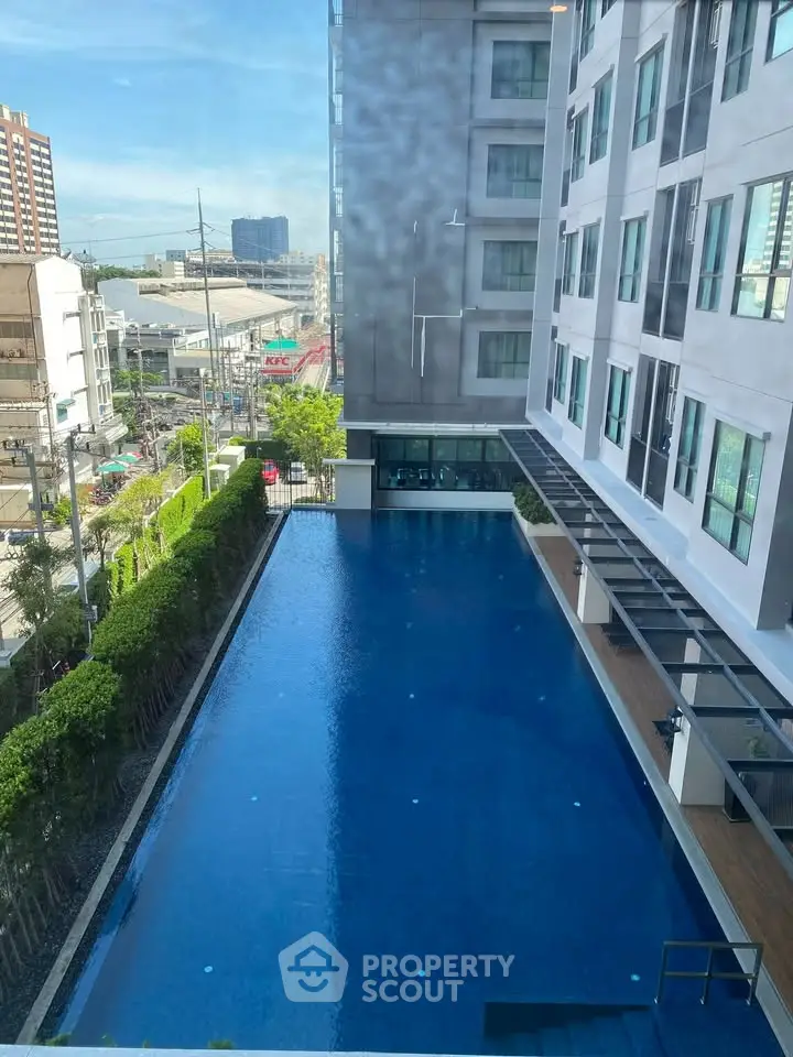Modern condominium with a spacious outdoor pool and city view, perfect for urban living.