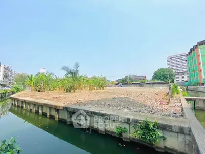 Prime real estate land plot with canal view in urban setting, ideal for development.