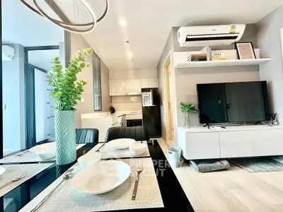 Modern open-layout living room with sleek kitchen, stylish decor, and contemporary furniture.