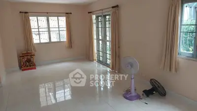 Spacious empty living room with large windows and tiled floor