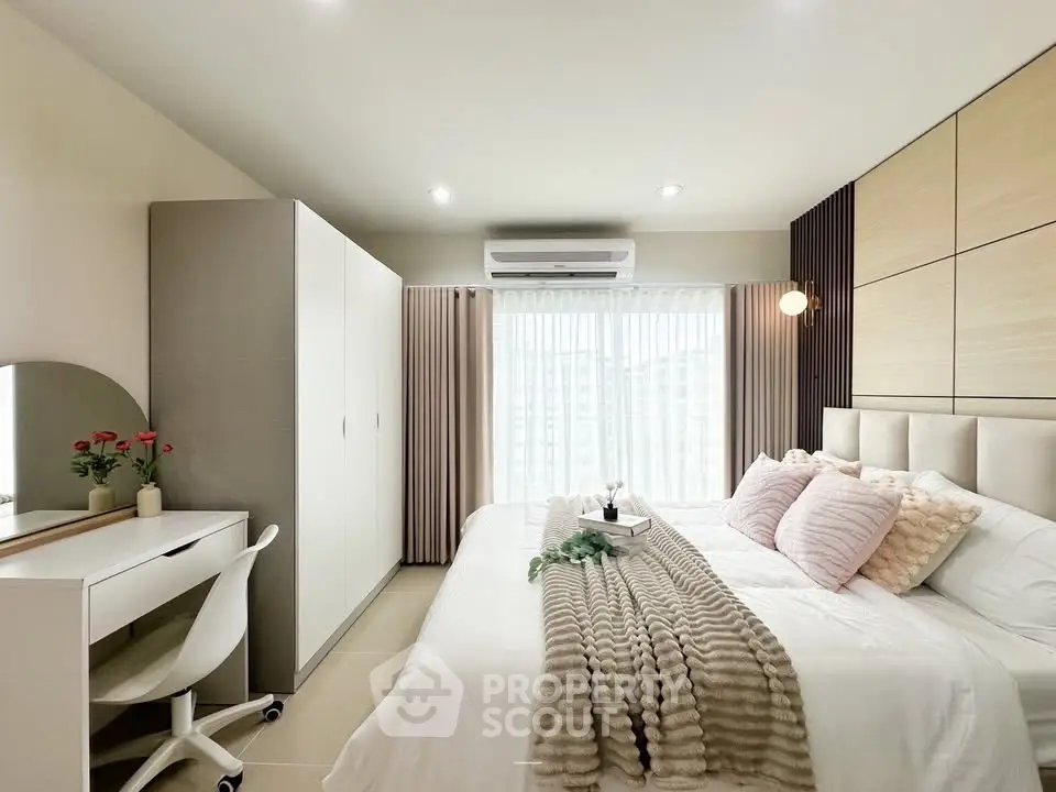 Modern bedroom with stylish decor and natural light, featuring a cozy bed and elegant furnishings.