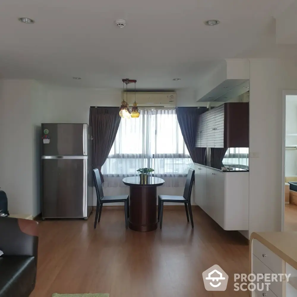 Modern open-plan kitchen and dining area with natural light and stylish furnishings.