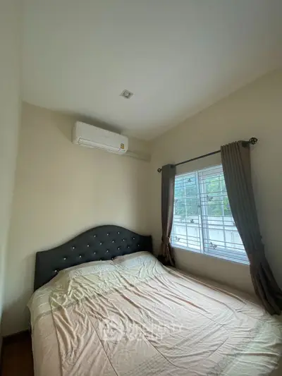 Cozy bedroom with air conditioning and large window for natural light