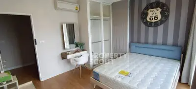 Modern bedroom with stylish decor and Route 66 wall clock, featuring a comfortable bed and sleek furniture.