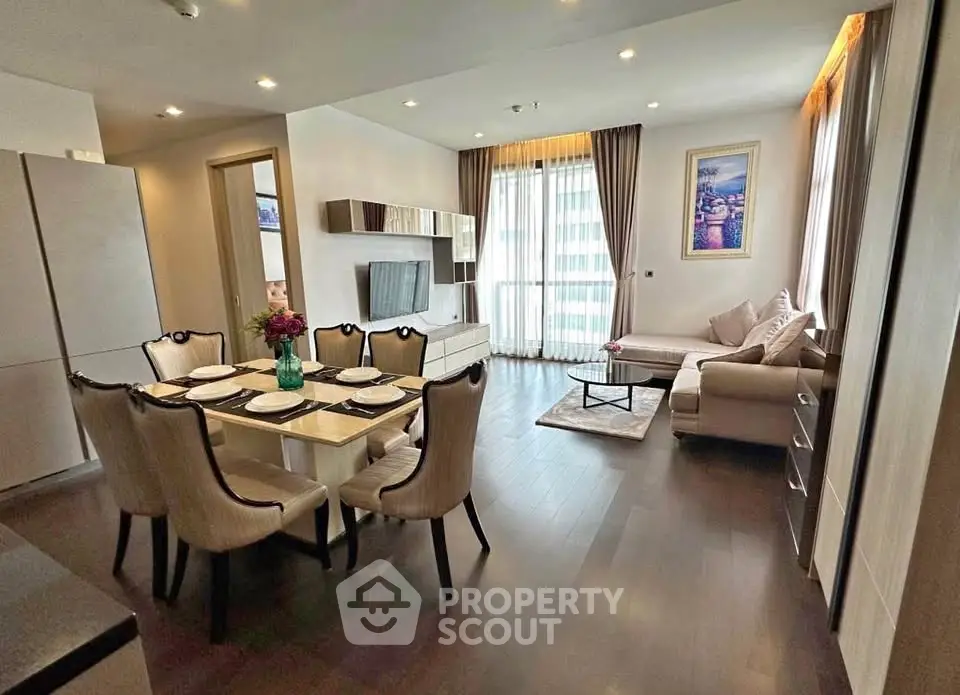 Elegant open-plan living room with dining area, modern decor, and natural light in a stylish apartment.