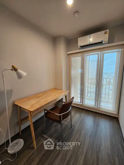 Cozy study room with wooden desk and chair, featuring large window and air conditioning.