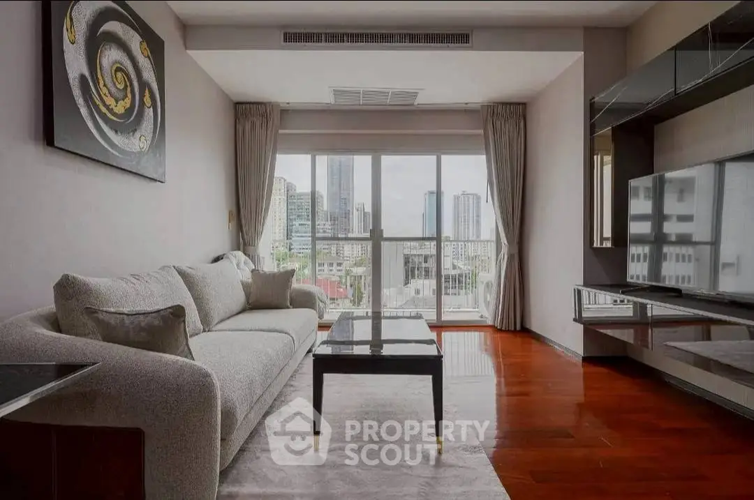 Modern living room with city view, stylish decor, and comfortable seating in a high-rise apartment.