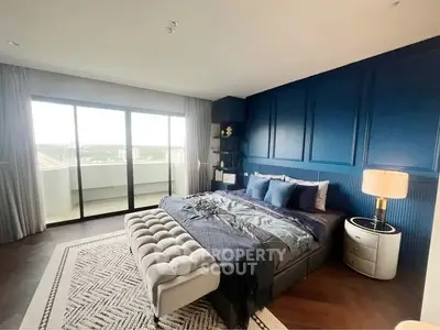 Luxurious bedroom with elegant blue accent wall and balcony view