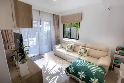 Cozy living room with natural light, modern decor, and comfortable seating.