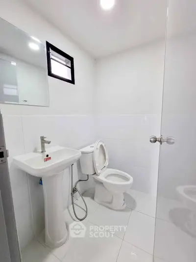 Modern white bathroom with sleek fixtures and natural light