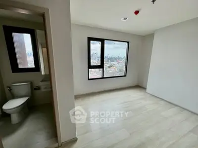 Spacious bedroom with city view and adjacent bathroom in modern apartment