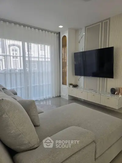 Modern living room with sleek TV setup and large windows