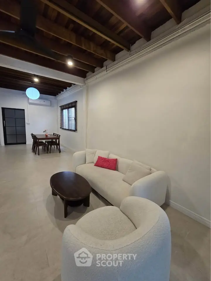 Spacious living room with modern furniture and exposed wooden beams