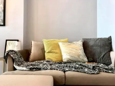 Cozy living room with stylish sofa and decorative pillows, perfect for relaxation.
