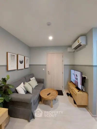 Cozy living room with modern decor and wall-mounted TV in a stylish apartment.