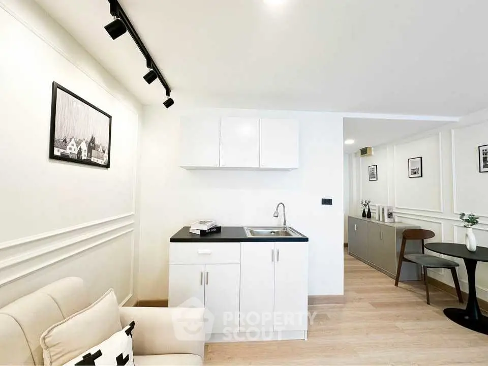 Modern minimalist living space with compact kitchenette and stylish decor.