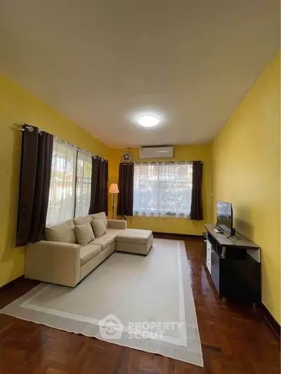 Spacious living room with cozy sofa and modern TV setup, perfect for relaxation.