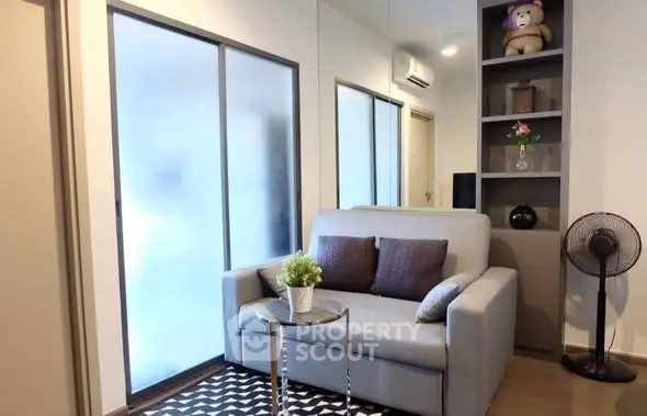 Cozy living room with modern sofa, stylish decor, and ample natural light.