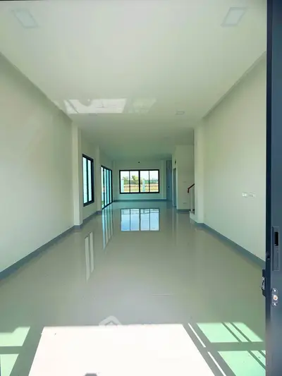 Spacious open-plan living area with large windows and glossy floors