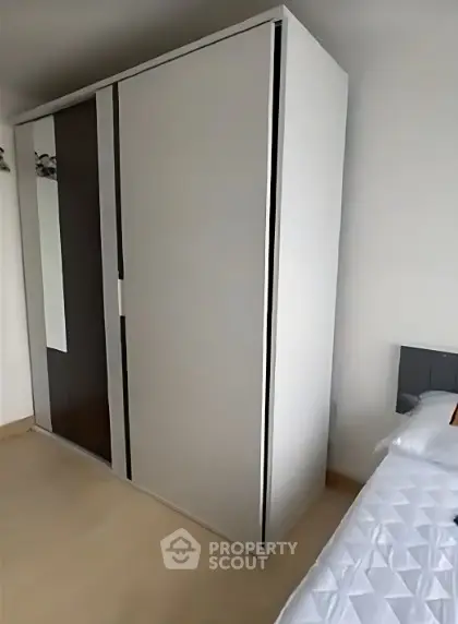 Modern bedroom with sleek wardrobe and cozy bed setup