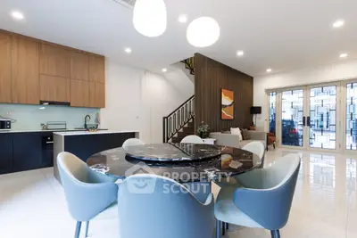 Modern open-plan living and dining area with stylish furniture and elegant lighting.