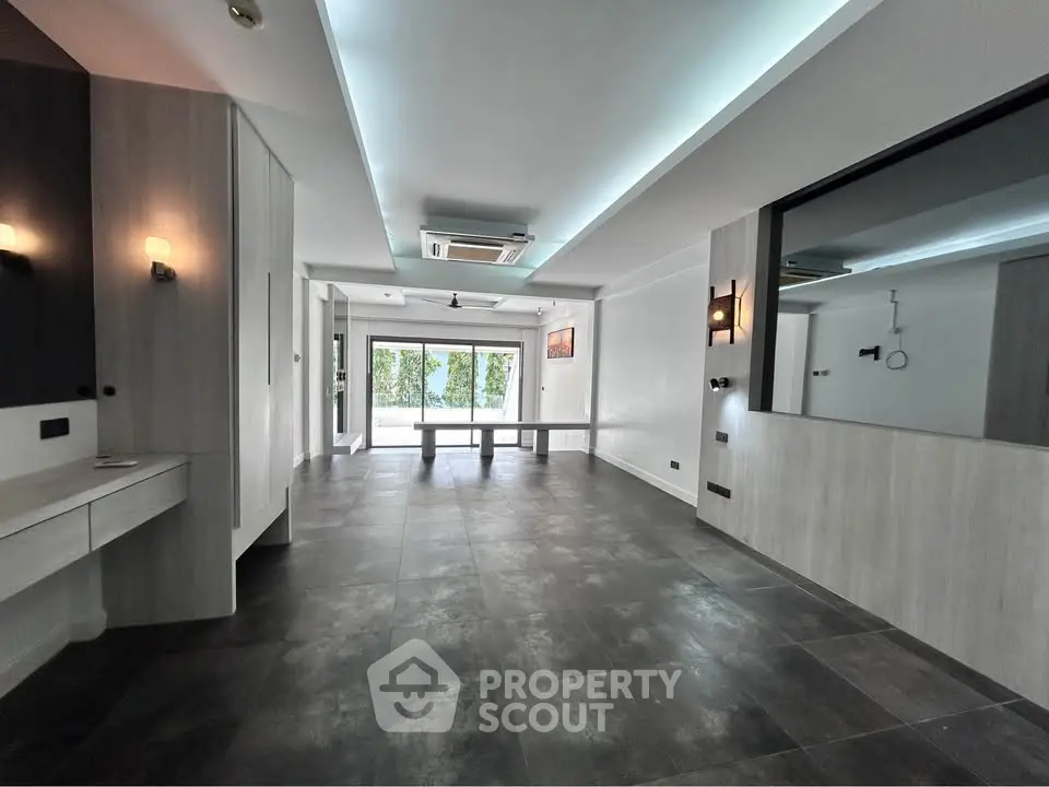Spacious modern living room with sleek design and large windows offering natural light.