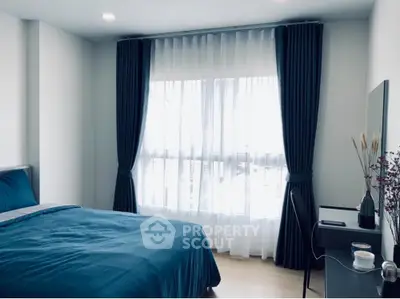 Serene bedroom with a large comfortable bed, elegant dark curtains, and ample natural light filtering through sheer drapes, creating a peaceful retreat.