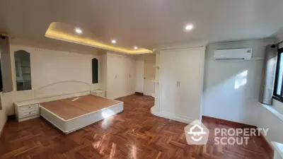 Spacious bedroom with elegant wooden flooring and built-in storage