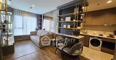 Modern living room with open kitchen, stylish decor, and natural light.