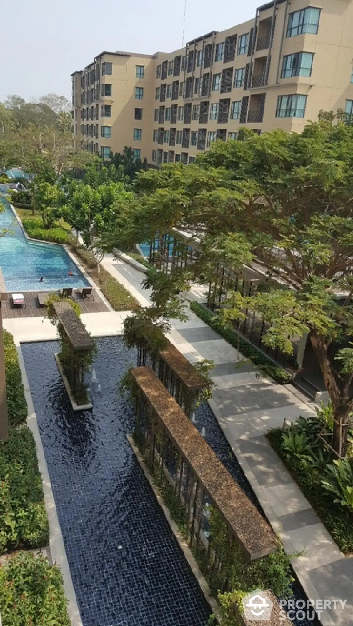 Luxurious apartment complex with stunning pool and lush garden view