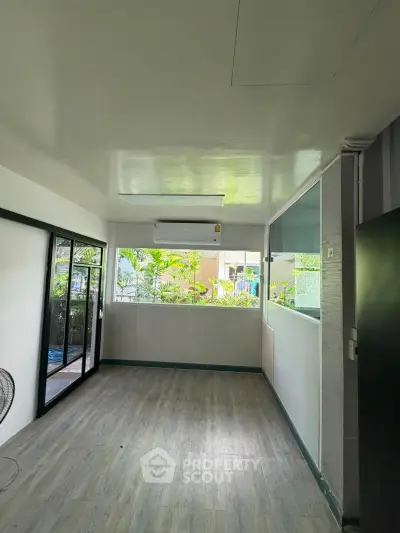 Spacious room with large windows and air conditioning, perfect for a bright and airy living space.