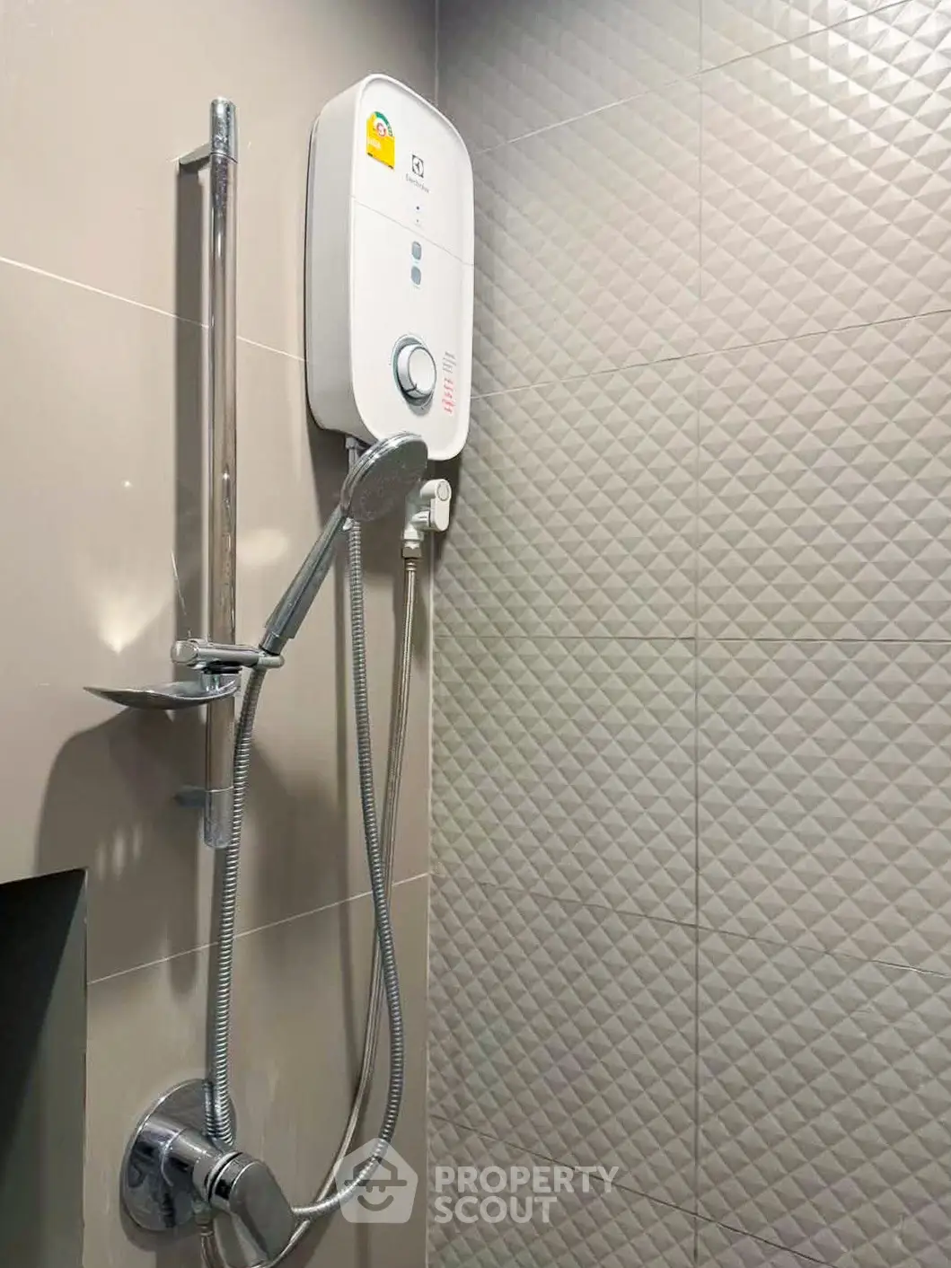 Modern bathroom with sleek showerhead and water heater on textured tile wall.
