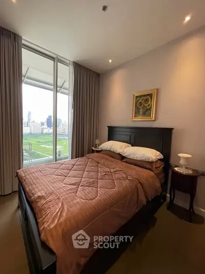 Cozy bedroom with city view, featuring elegant decor and natural light.