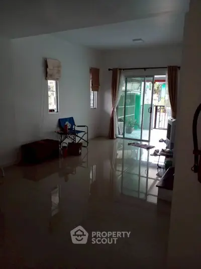 Spacious living room with sliding glass doors and tiled flooring.