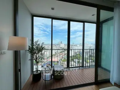 Stunning city view from modern apartment balcony with floor-to-ceiling windows.