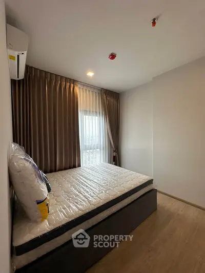 Cozy bedroom with natural light and modern decor, featuring a comfortable bed and elegant curtains.