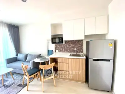 Modern open-layout kitchen with dining area and cozy living space in bright apartment.