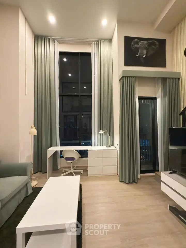 Modern living room with high ceilings, elegant decor, and large windows offering city views.