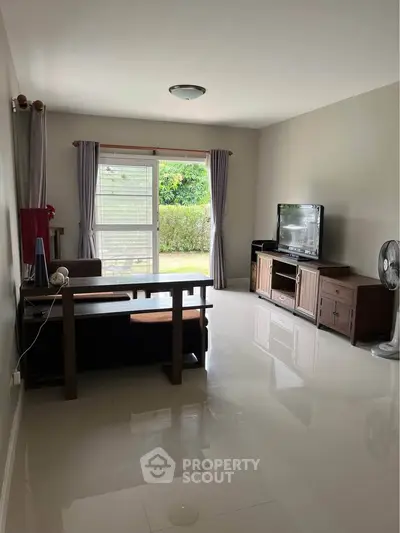 Spacious living room with modern furniture and garden view, perfect for relaxation.