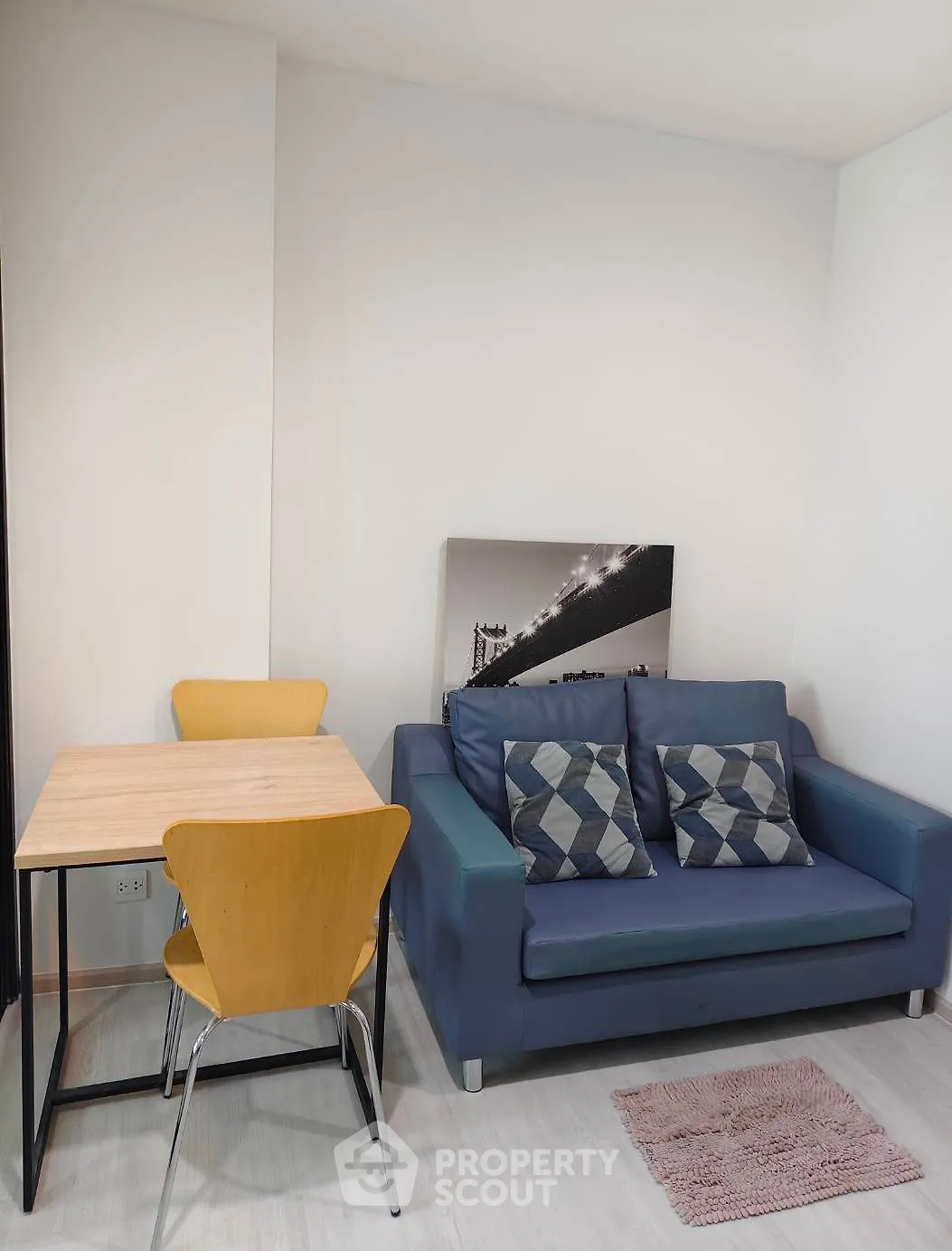 Cozy living room with modern sofa and dining area, perfect for urban living.