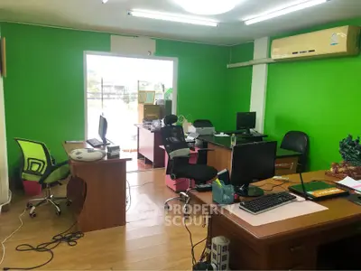 Spacious office space with vibrant green walls and modern furniture, ideal for a productive work environment.