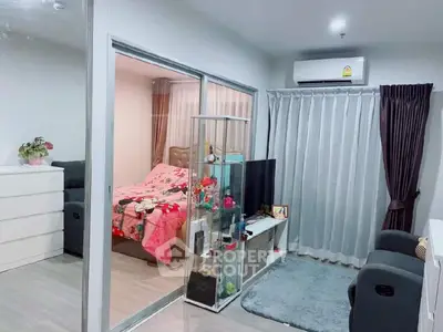 Modern apartment interior with cozy living room and stylish bedroom separated by glass doors.