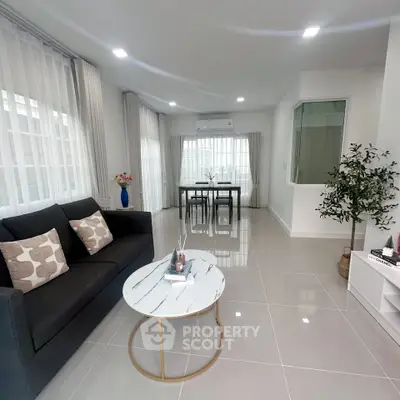 Modern living room with sleek furniture and large windows in a bright, airy space.