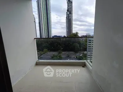 Spacious balcony with stunning cityscape view in modern high-rise apartment.