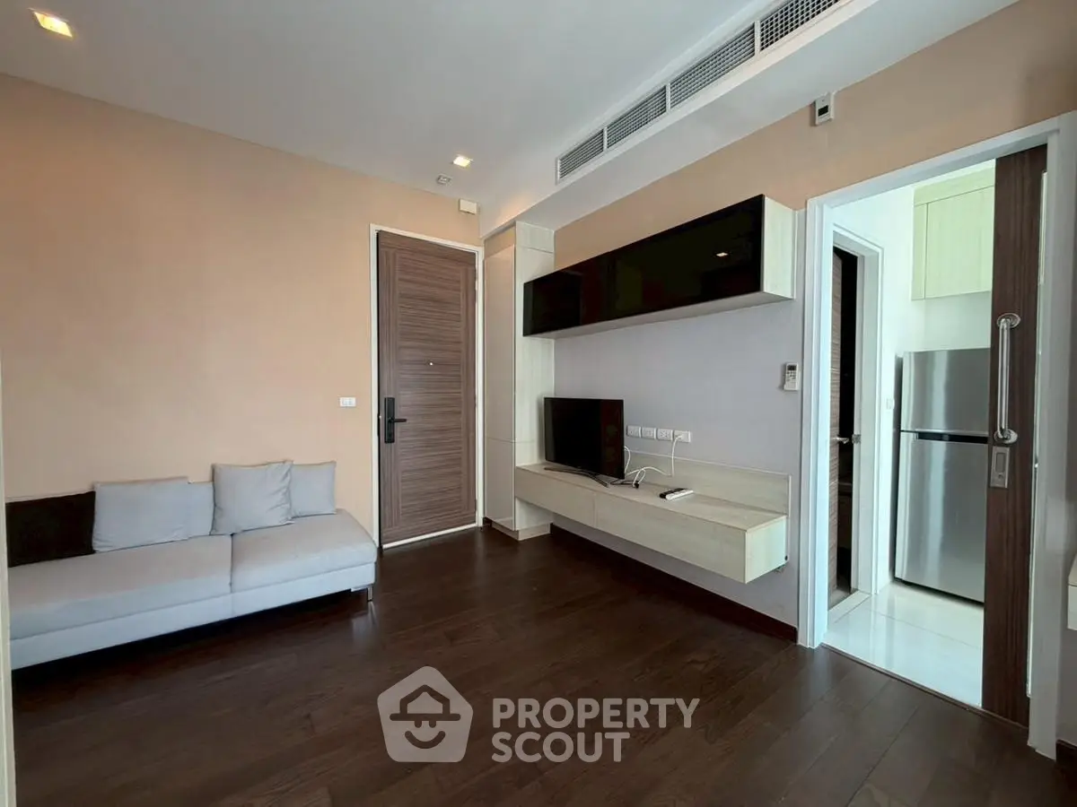 Modern living room with sleek furniture and wooden flooring in a stylish apartment.
