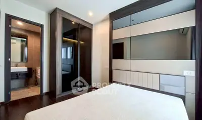 Modern bedroom with ensuite bathroom and sleek mirrored wardrobe