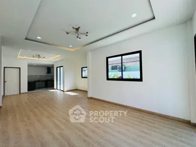 Spacious open-plan living room with modern kitchen and large windows