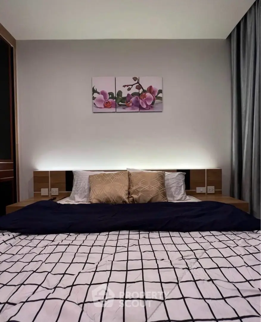 Modern bedroom with stylish decor and cozy bedding in a contemporary apartment.